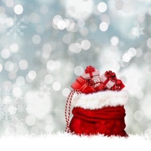 Christmas gifts in a red Santa bag with snowflakes in the background